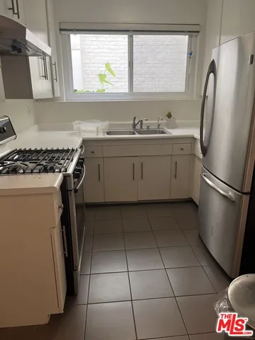 a kitchen with a stove a refrigerator and a sink