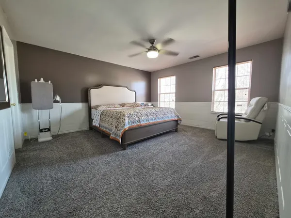 a spacious bedroom with a bed and a chandelier