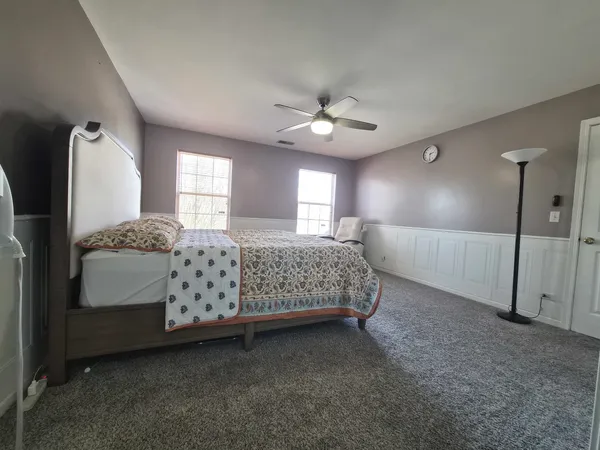 a spacious bedroom with a bed dresser and a window