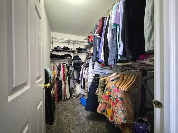 a view of walk in closet with clothes