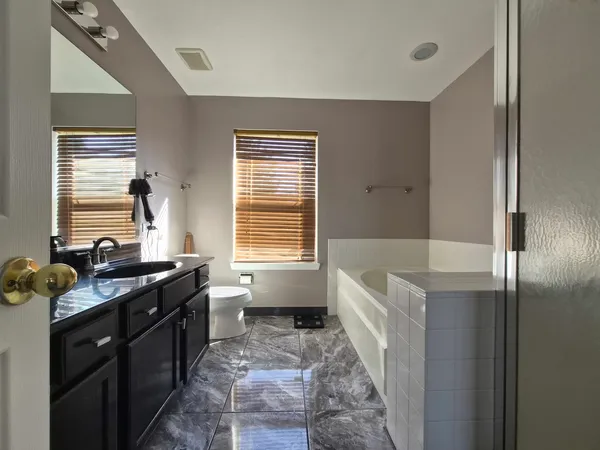 a bathroom with a tub sink and mirror