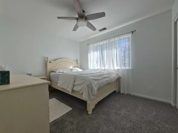 a bedroom with a bed and a ceiling fan