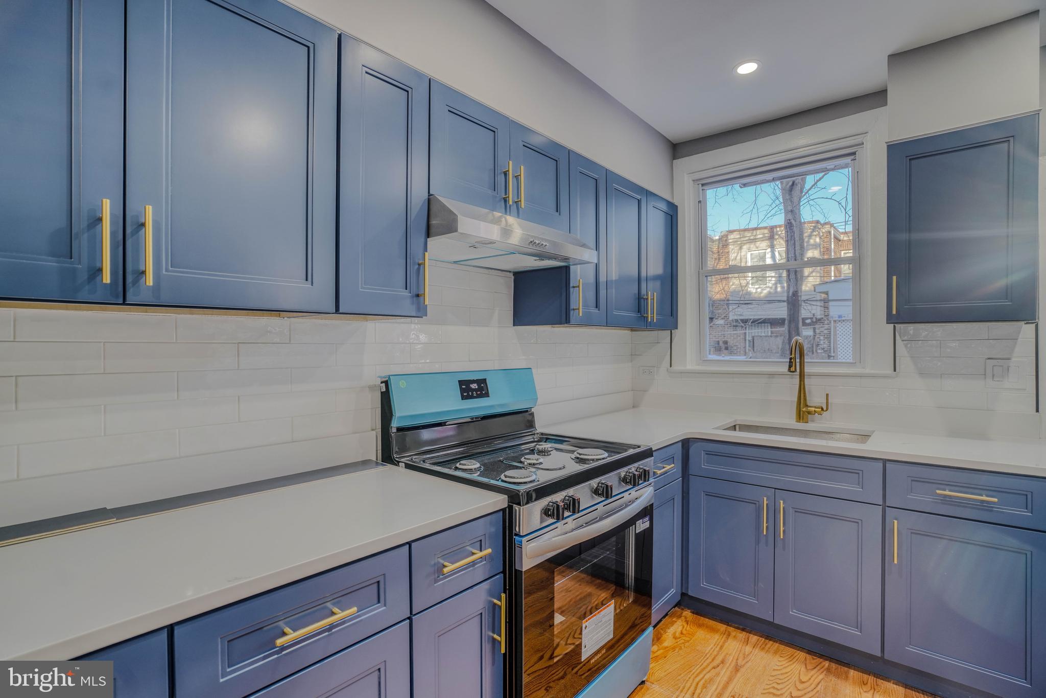 2135 Granite Street Philadelphia, PA 19124 - Photo 11 of 34 a kitchen with stainless steel appliances a stove a sink cabinets and a window