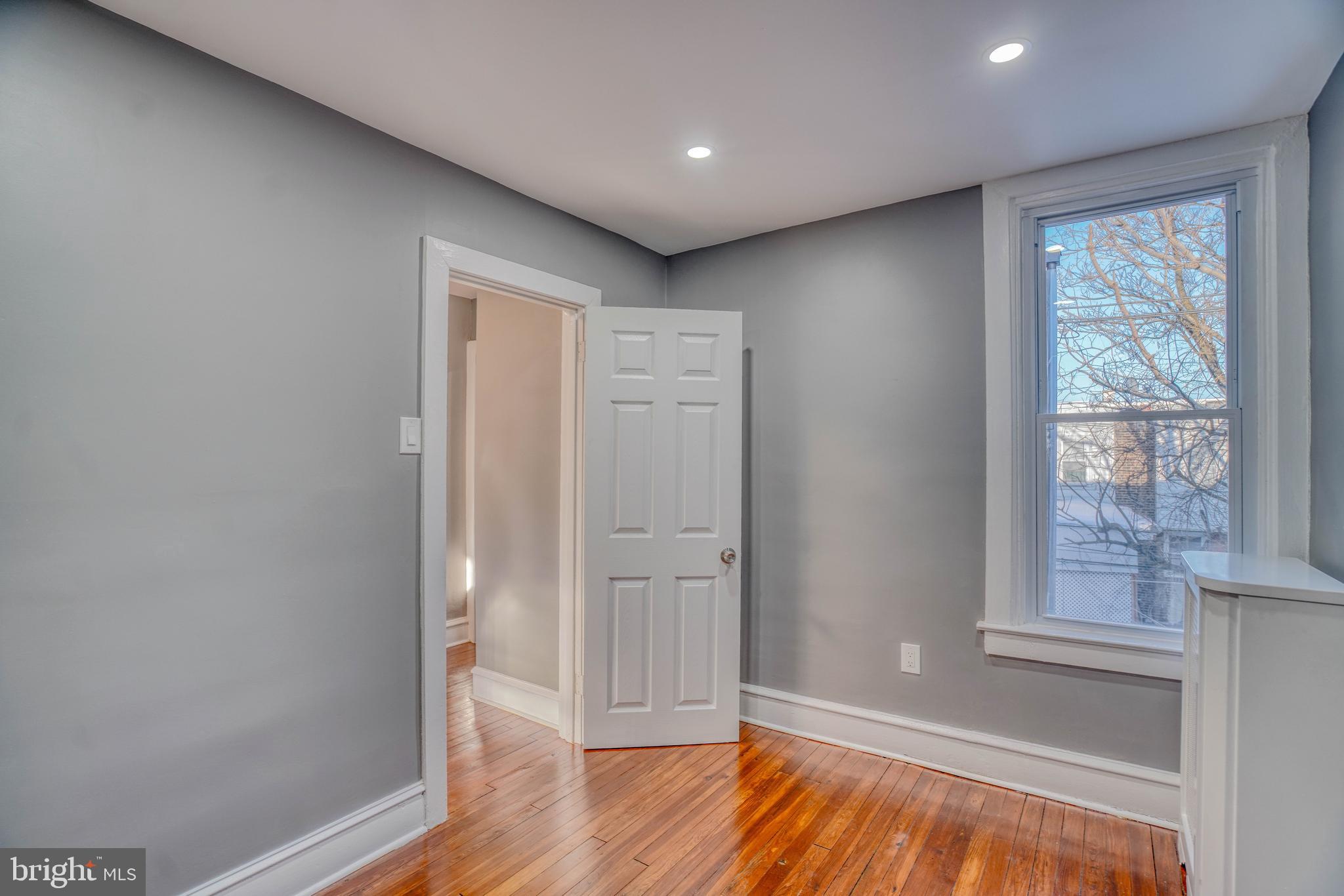 2135 Granite Street Philadelphia, PA 19124 - Photo 23 of 34 an empty room with wooden floor and windows