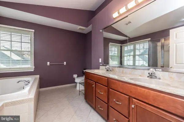 a spacious bathroom with a granite countertop tub sink and mirror