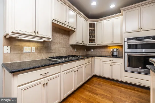 a kitchen with stainless steel appliances granite countertop a sink a stove and cabinets