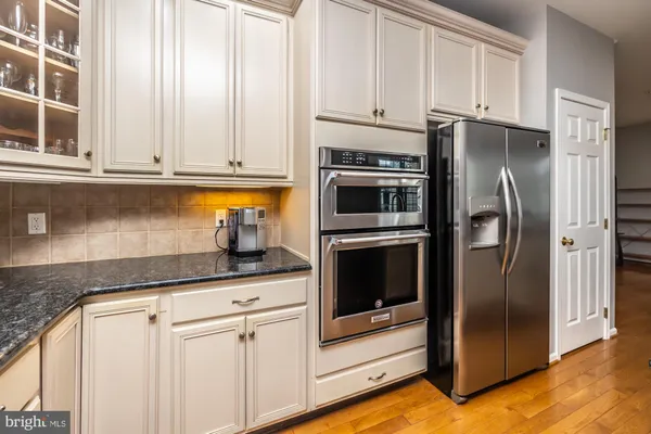 a kitchen with granite countertop white cabinets and stainless steel appliances