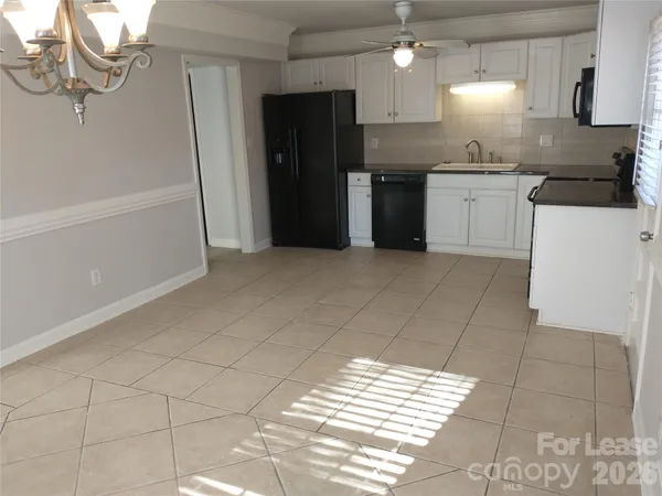 a kitchen with granite countertop a refrigerator and a stove top oven