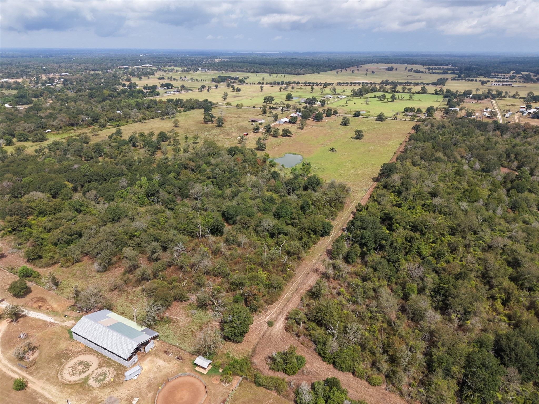 38021 Wiggins Road Hempstead, TX 77445 - Photo 9 of 19 Aerial view showcasing the property’s long tract configuration, open acreage, wooded areas, and surrounding countryside.