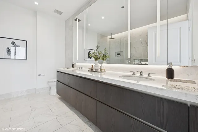 a bathroom with a double vanity sink a mirror and a bathtub