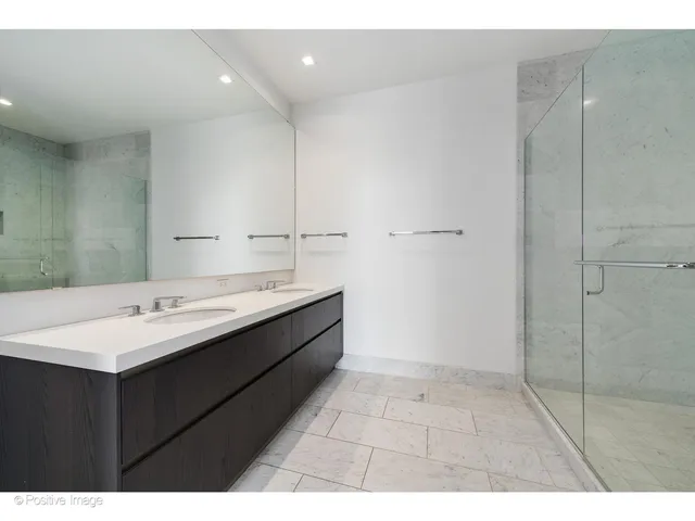 a bathroom with a sink mirror and shower