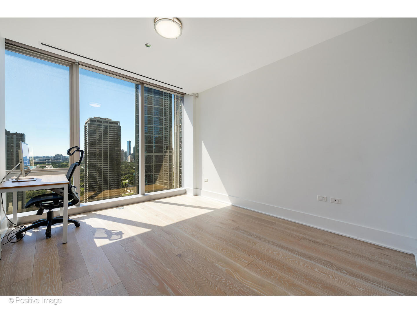 363 East Wacker Drive, Unit 1903 Chicago, IL 60601 - Photo 21 of 39 a view of an empty room with wooden floor and a window