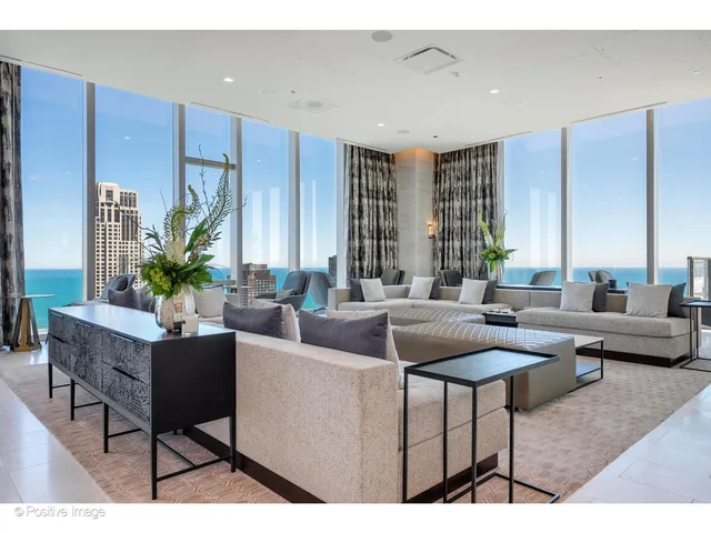 a living room with furniture potted plant and a large window