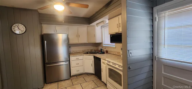 a kitchen with a refrigerator sink and cabinets