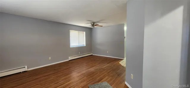 an empty room with a window and a ceiling fan