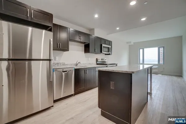 a kitchen with stainless steel appliances a refrigerator and a stove top oven