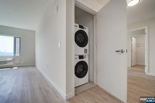a view of walk in closet with wooden floor and washer