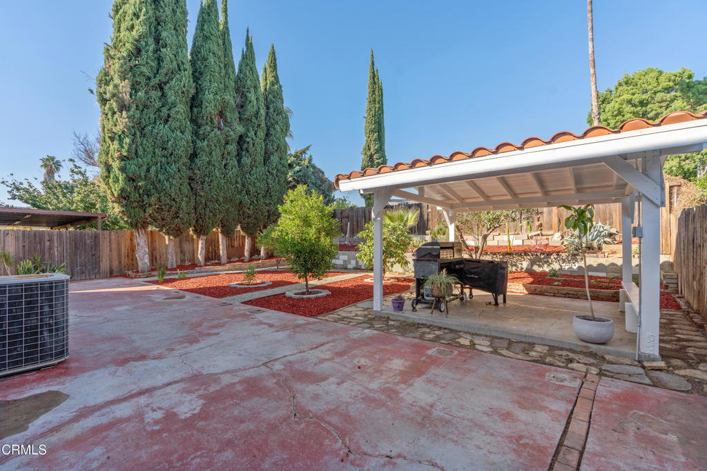 18719 Chase Street Northridge, CA 91324 - Photo 30 of 32 a view of a patio with a table and chairs under an umbrella with wooden fence