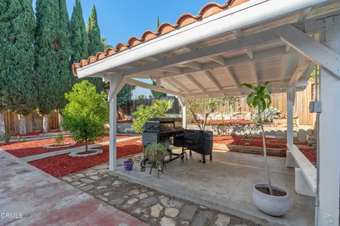 a patio with table and chairs and potted plants