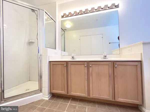 a bathroom with a double vanity sink toilet and shower