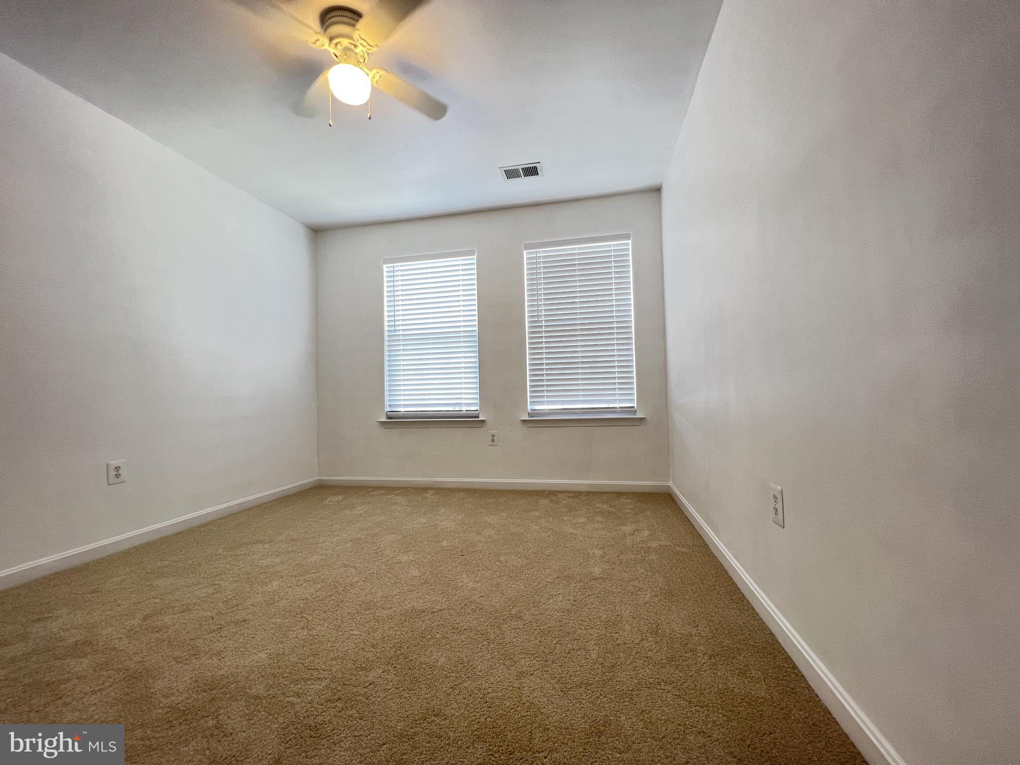 4971 Clarendon Terrace Frederick, MD 21703 - Photo 21 of 35 an empty room with a chandelier fan and windows