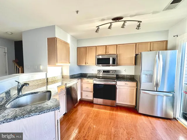 a kitchen with granite countertop a refrigerator and a sink