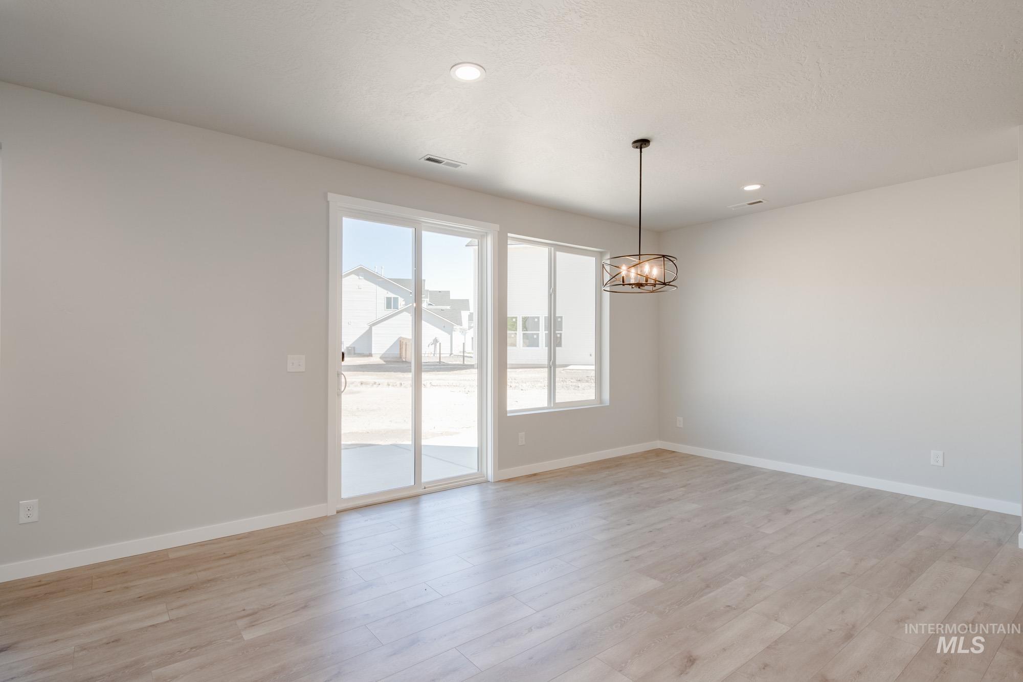 13708 Judson Street Caldwell, ID 83607 - Photo 13 of 32 Unfurnished room featuring light wood-style flooring, a chandelier, and recessed lighting
