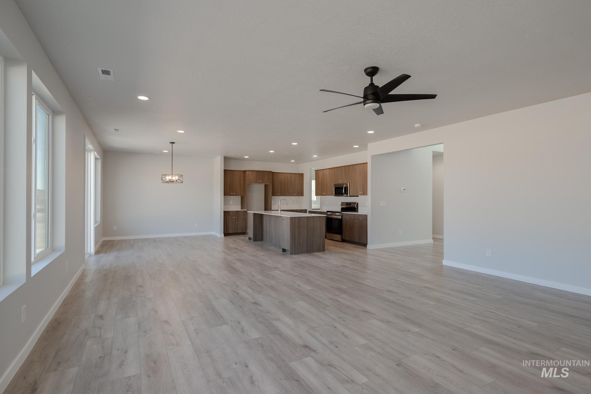 13708 Judson Street Caldwell, ID 83607 - Photo 16 of 32 Unfurnished living room with recessed lighting, light wood-type flooring, ceiling fan, and a chandelier