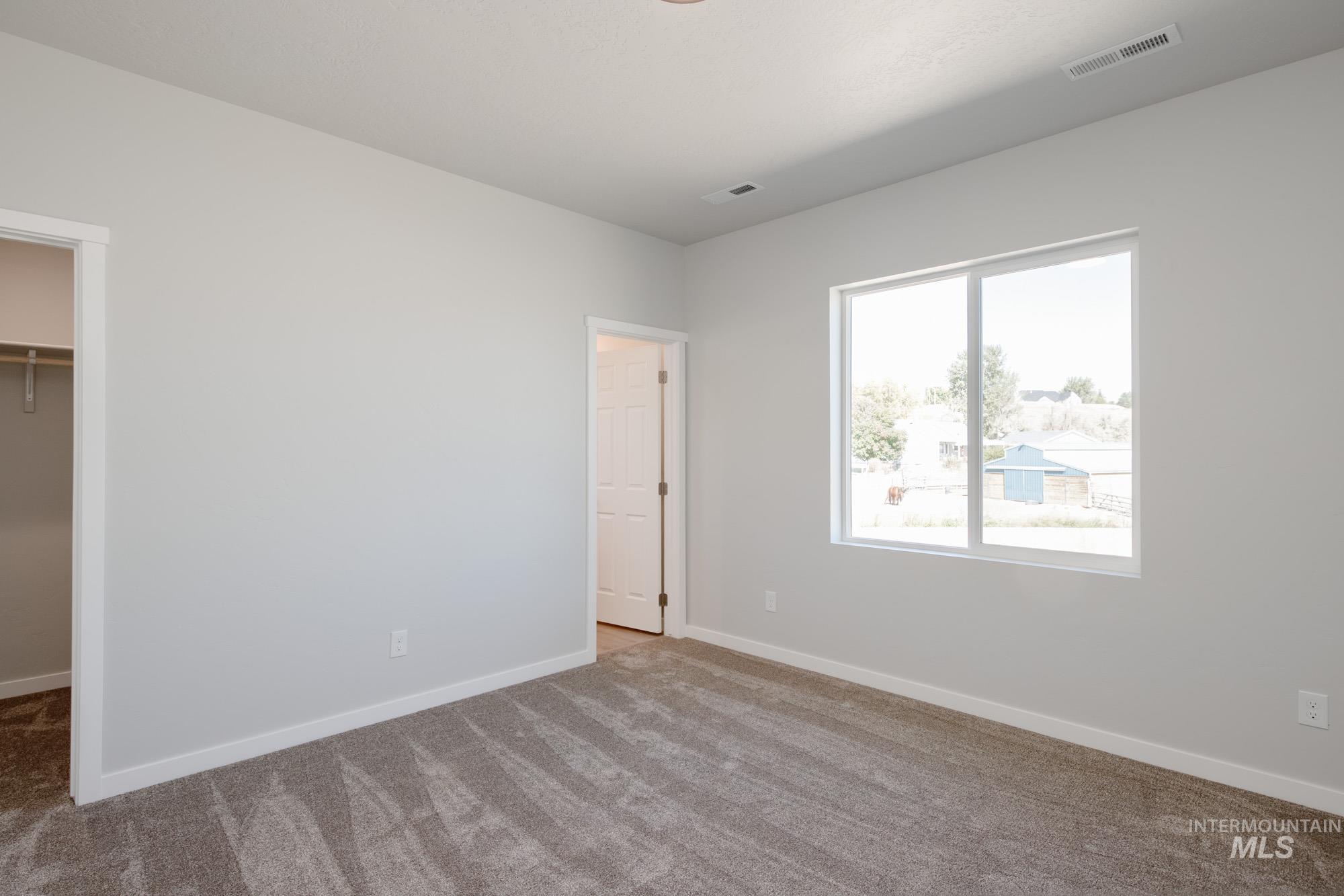 13708 Judson Street Caldwell, ID 83607 - Photo 22 of 32 Unfurnished bedroom featuring a walk in closet and carpet