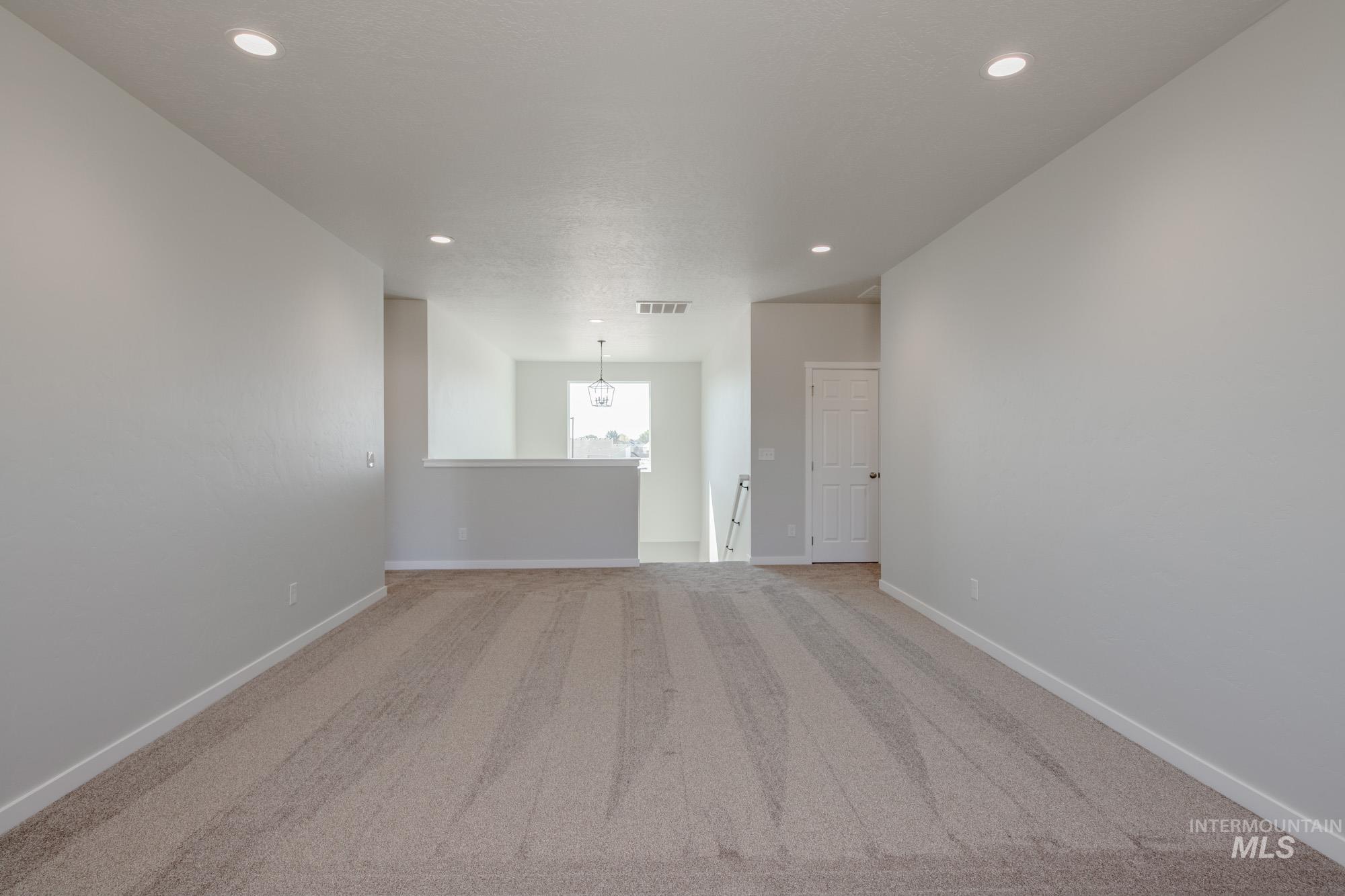 13708 Judson Street Caldwell, ID 83607 - Photo 25 of 32 Carpeted spare room featuring a chandelier and recessed lighting