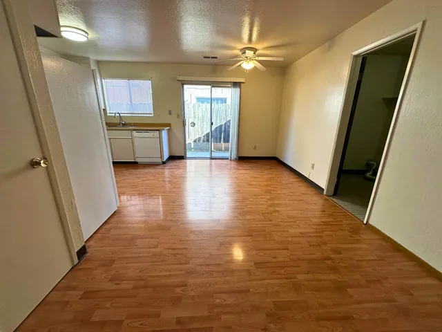 a kitchen with granite countertop a refrigerator a stove and a wooden floors