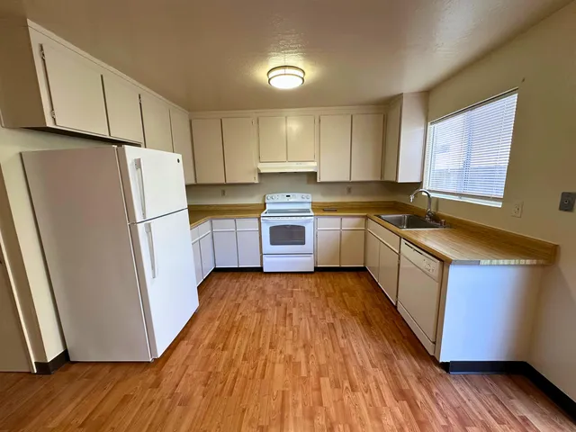 a view of an empty room with wooden floor and closet