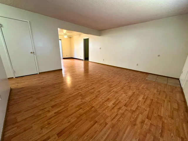 a view of a kitchen with a refrigerator a ceiling fan and wooden floor
