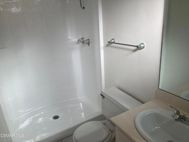 a bathroom with a granite countertop toilet sink and shower
