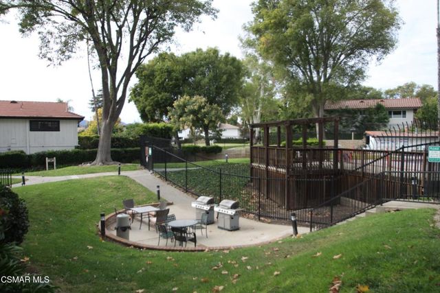a view of a chair and table in backyard of the house