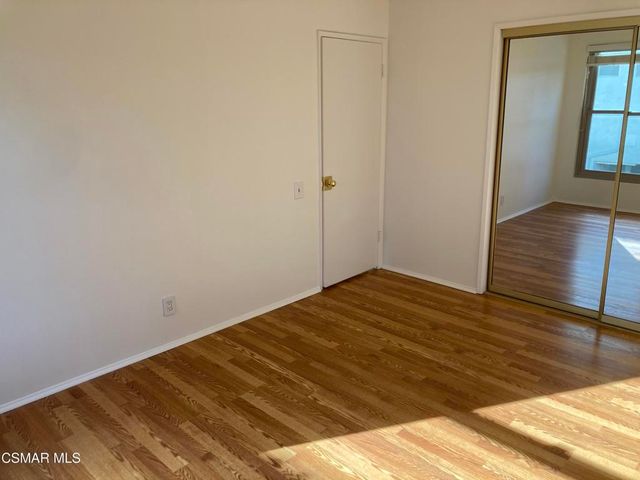 a view of a room with wooden floor and bench