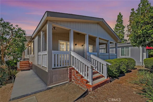 a view of a house with a small yard and wooden fence