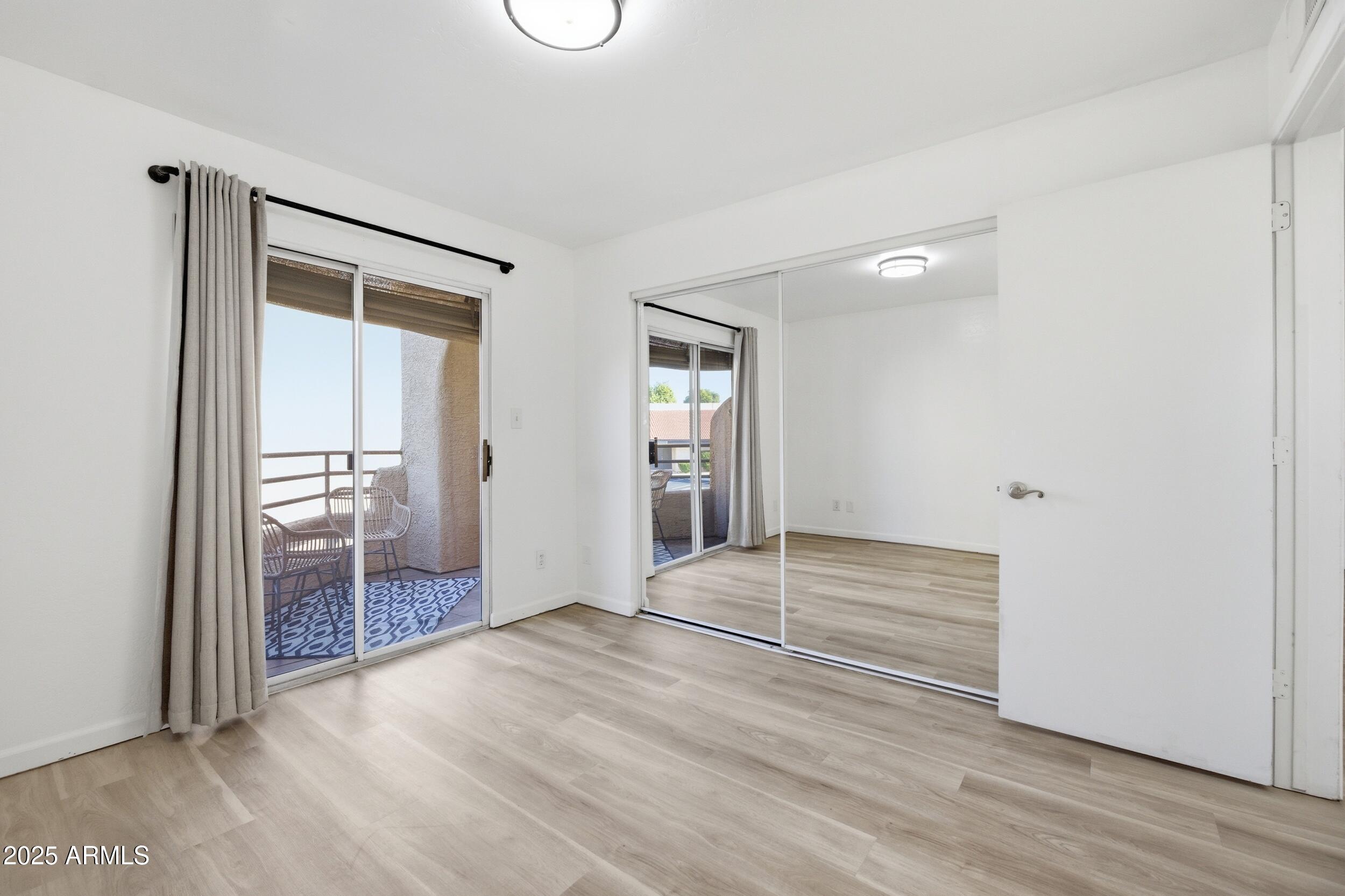 3845 East Greenway Road, Unit 230 Phoenix, AZ 85032 - Photo 9 of 37 a view of an empty room with wooden floor and a window