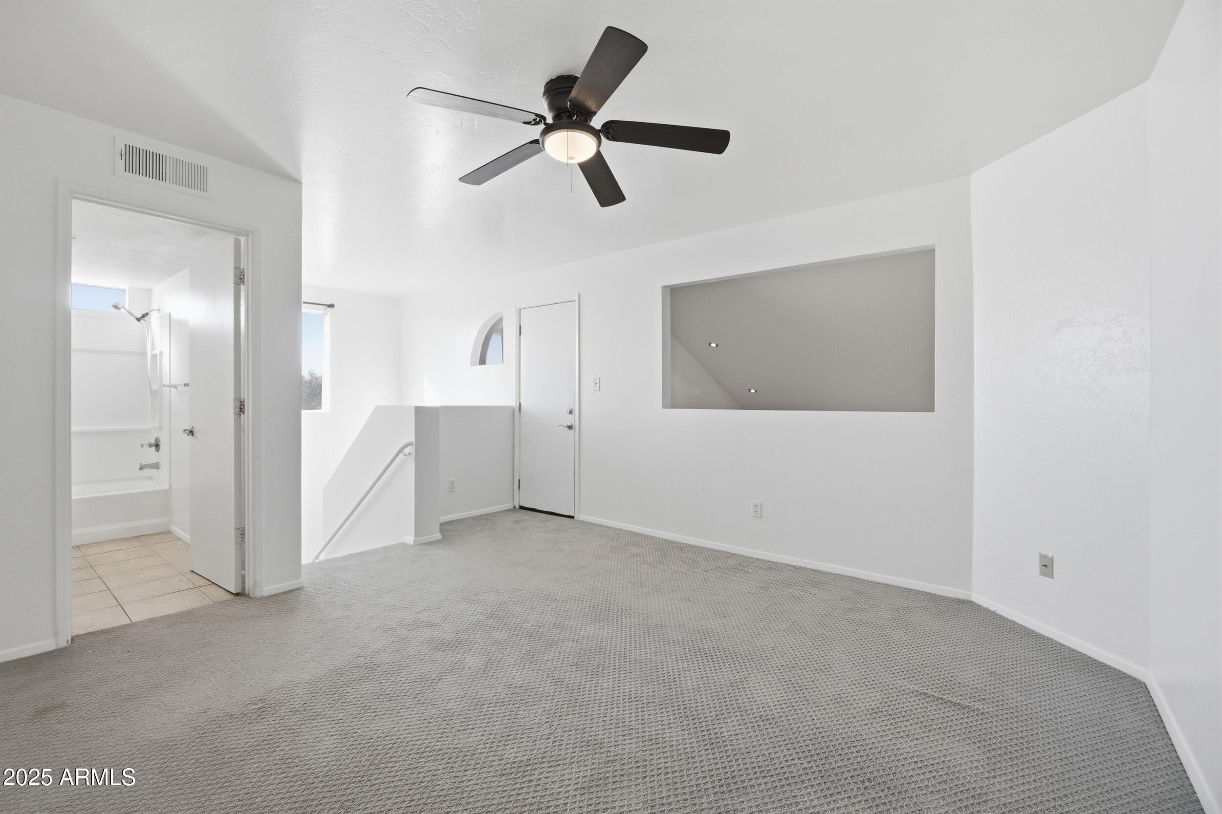 3845 East Greenway Road, Unit 230 Phoenix, AZ 85032 - Photo 12 of 37 an empty room with closet and windows