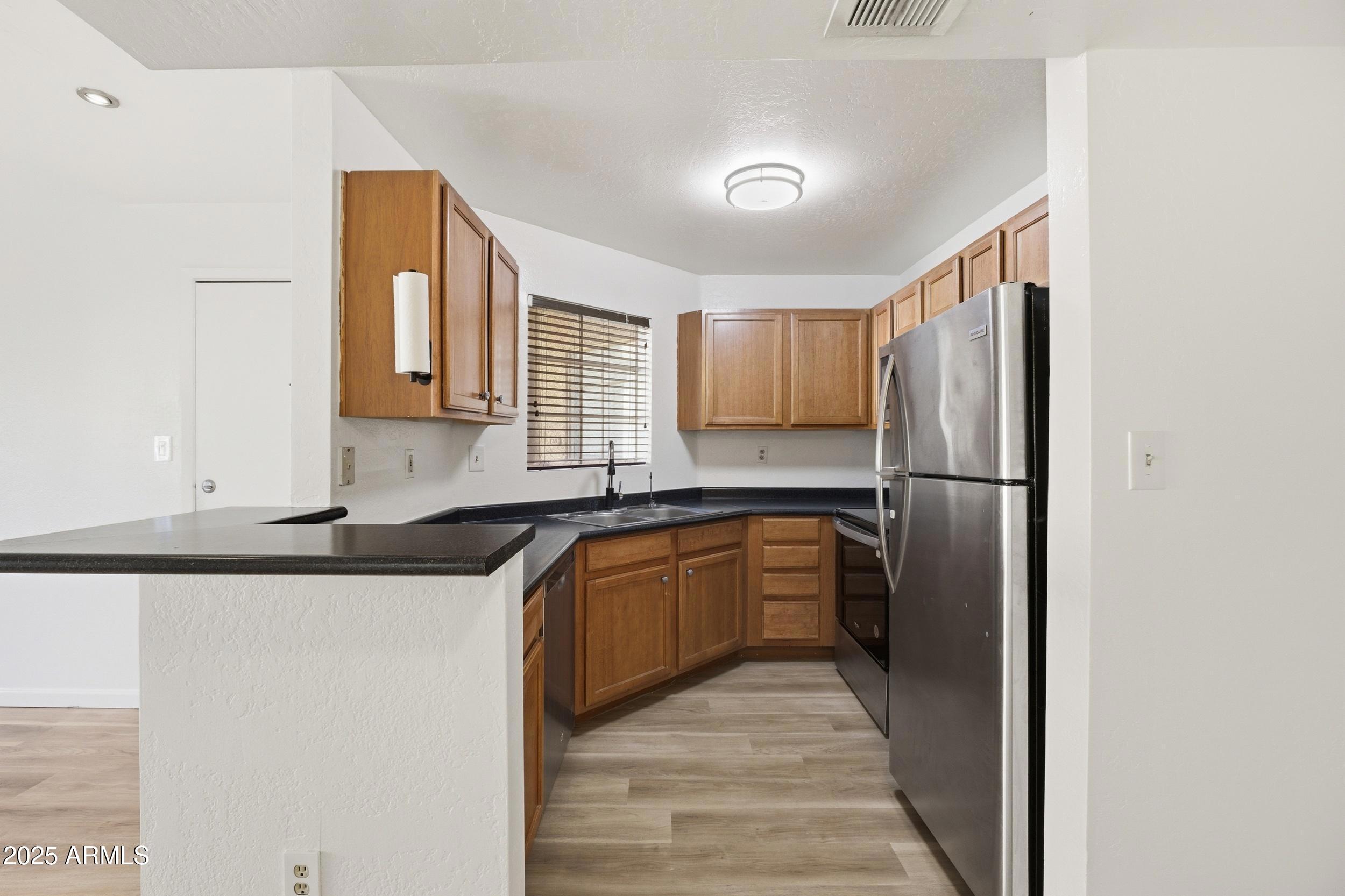 3845 East Greenway Road, Unit 230 Phoenix, AZ 85032 - Photo 5 of 37 a kitchen with granite countertop a refrigerator and a sink