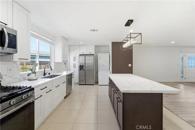 a kitchen with stainless steel appliances a refrigerator and a stove top oven