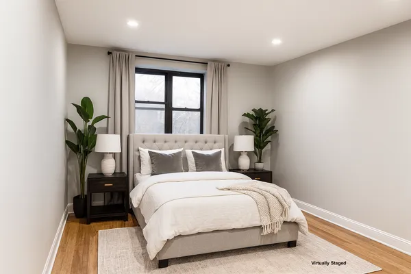 a bedroom with a large bed and a potted plant