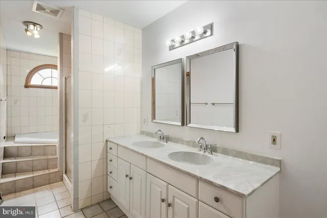 a bathroom with a granite countertop sink a mirror and a shower