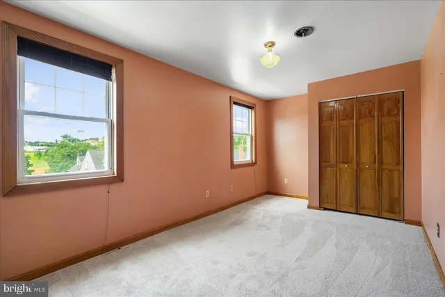 an empty room with windows and closet