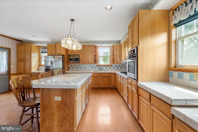 a kitchen with granite countertop counter space a sink appliances and a large window