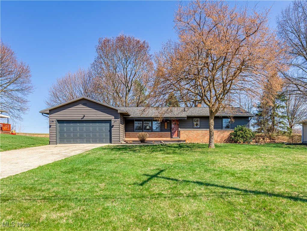 3995 Cottage Grove Road Uniontown, OH 44685 - Photo 2 of 29 Ranch-style home with a chimney, a front yard, an attached garage, and concrete driveway