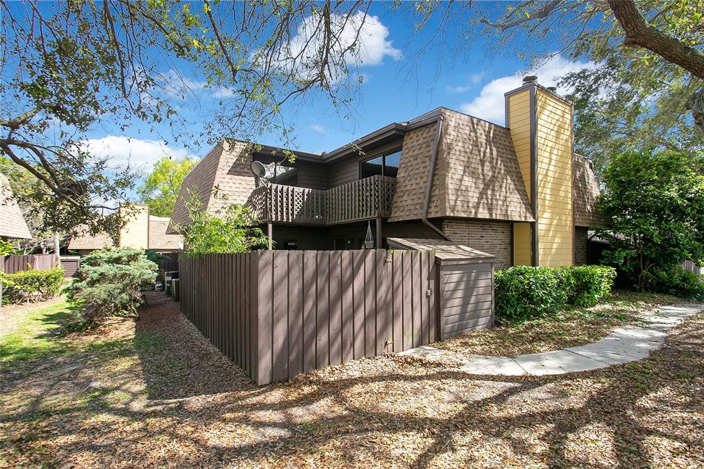 a view of a house with a yard and potted plants