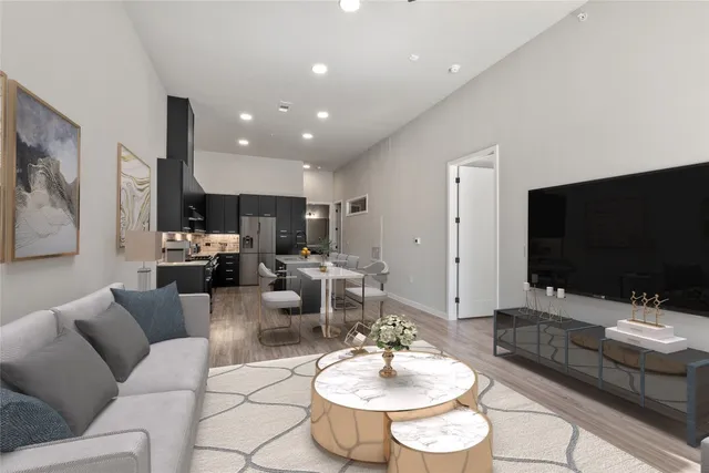 a kitchen with stainless steel appliances a stove refrigerator sink cabinets and wooden floor