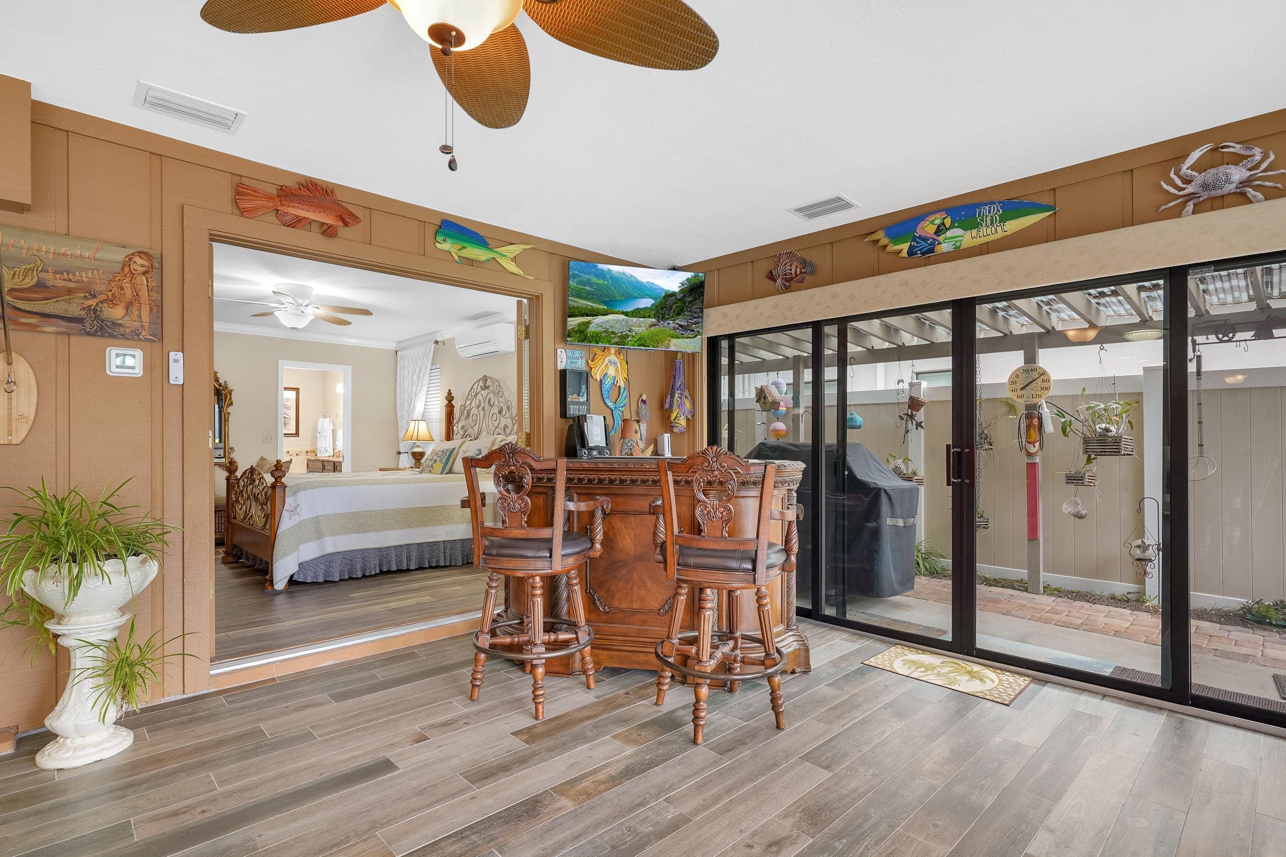 4 Calusa Court Palm Coast, FL 32137 - Photo 14 of 51 Interior space with wooden walls, wood finished floors, crown molding, a dry bar, and a wall unit AC