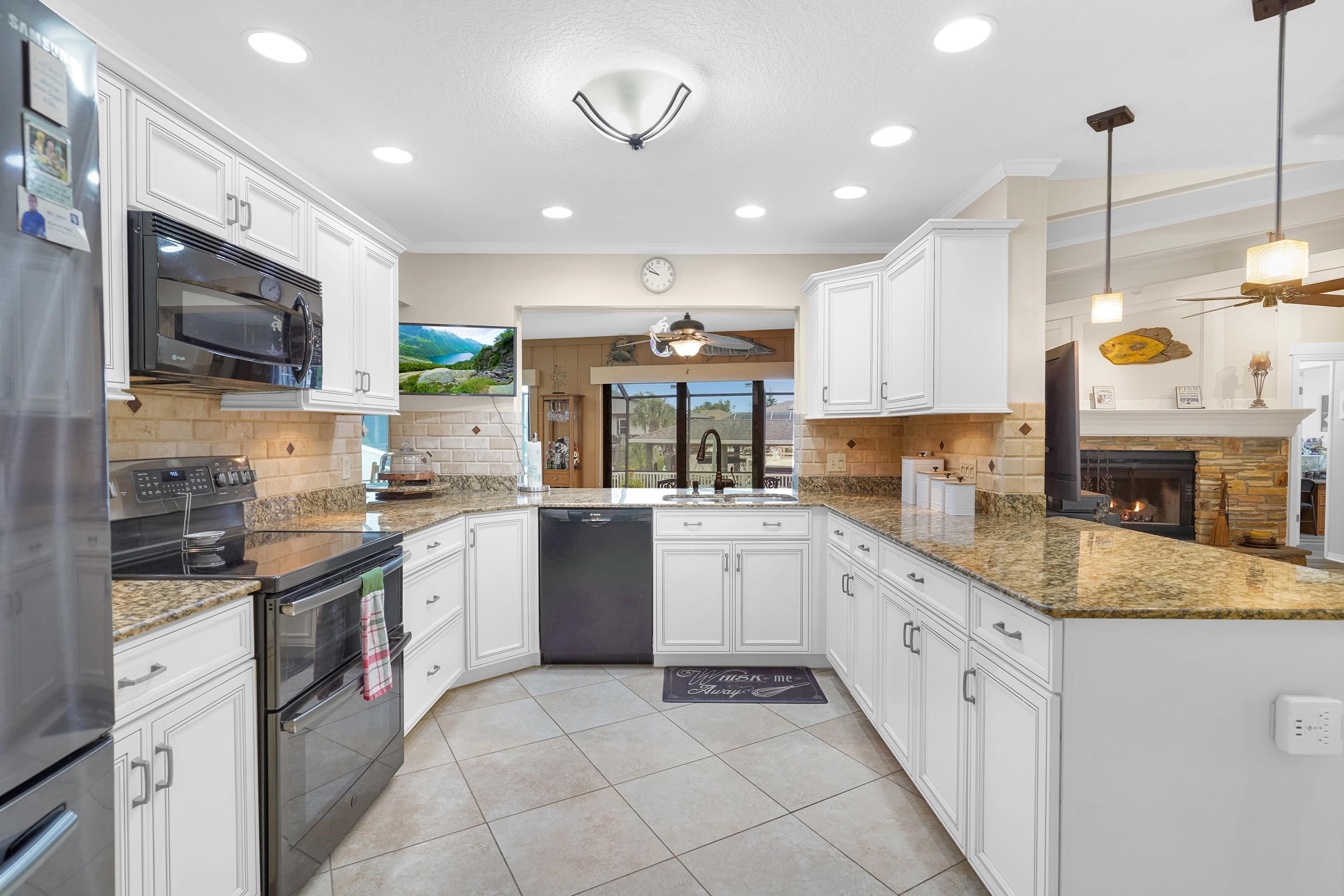 4 Calusa Court Palm Coast, FL 32137 - Photo 16 of 51 a kitchen with stainless steel appliances granite countertop a stove top oven a sink dishwasher and a microwave oven on the blue kitchen countertops